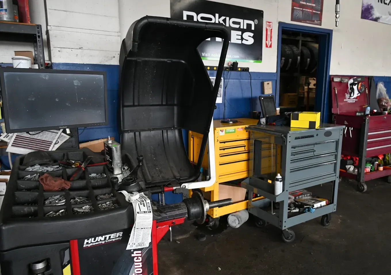 Automotive workshop with a vehicle simulator rig, tools, cabinets, and equipment in a garage. | Jones Complete Car Care