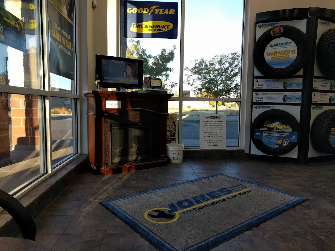 Goodyear tire shop interior with display counter, TV, and tire racks by the entrance | Jones Complete Car Care