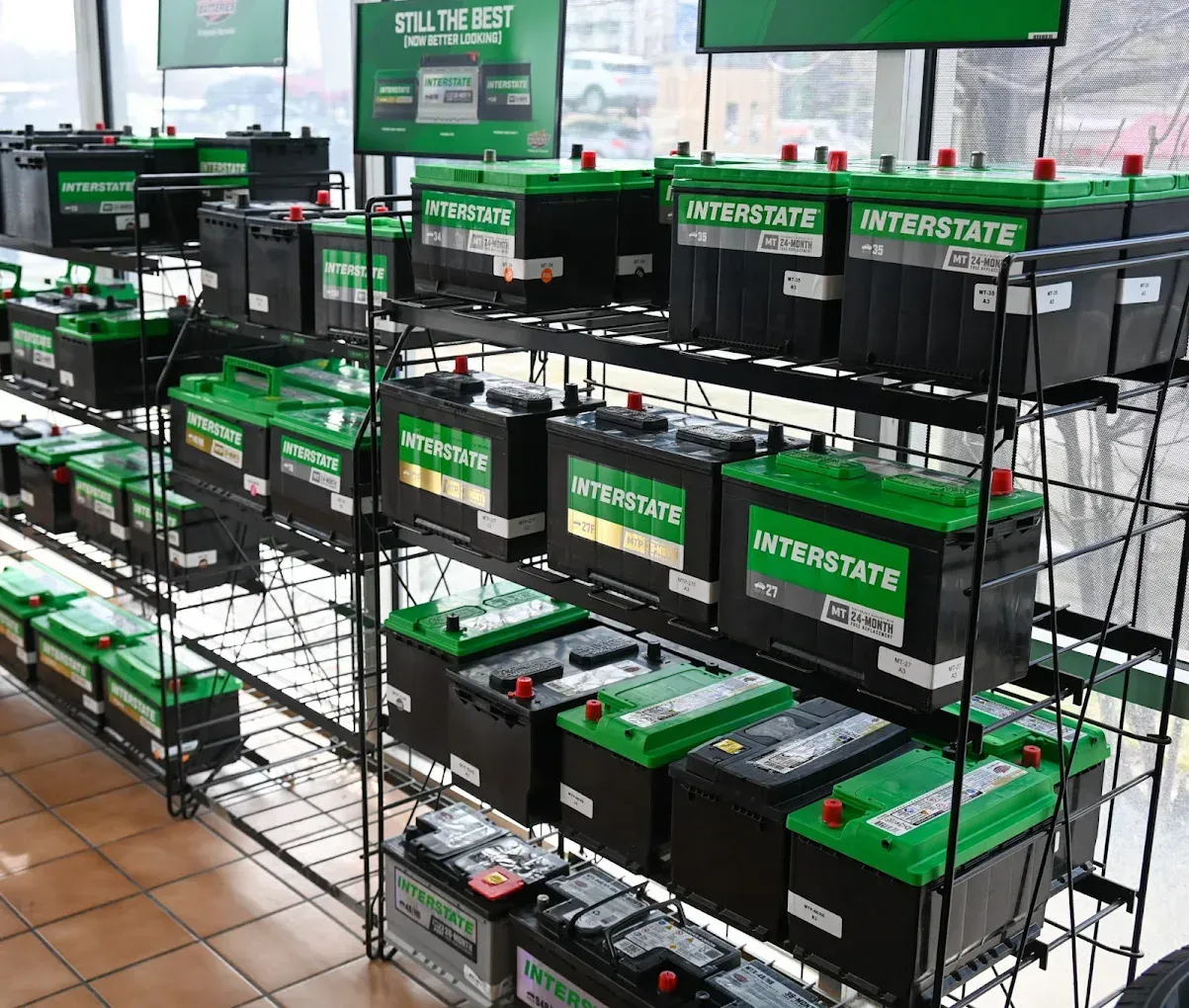 Rows of Interstate car batteries on metal racks in a store | Jones Complete Car Care