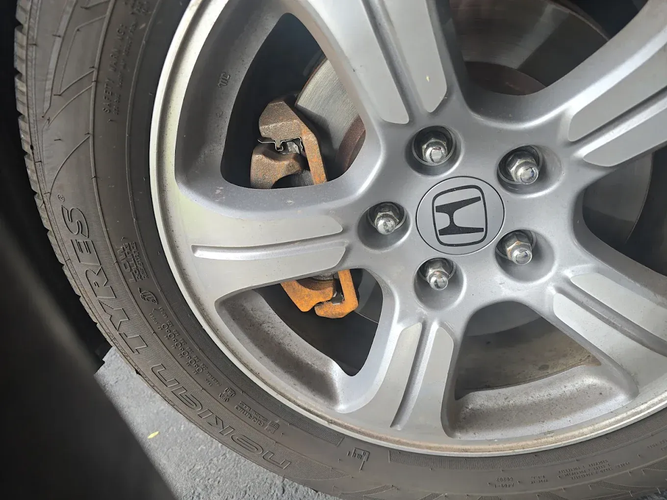 Close-up of a Honda wheel with a visible brake caliper behind the silver rim | Jones Complete Car Care