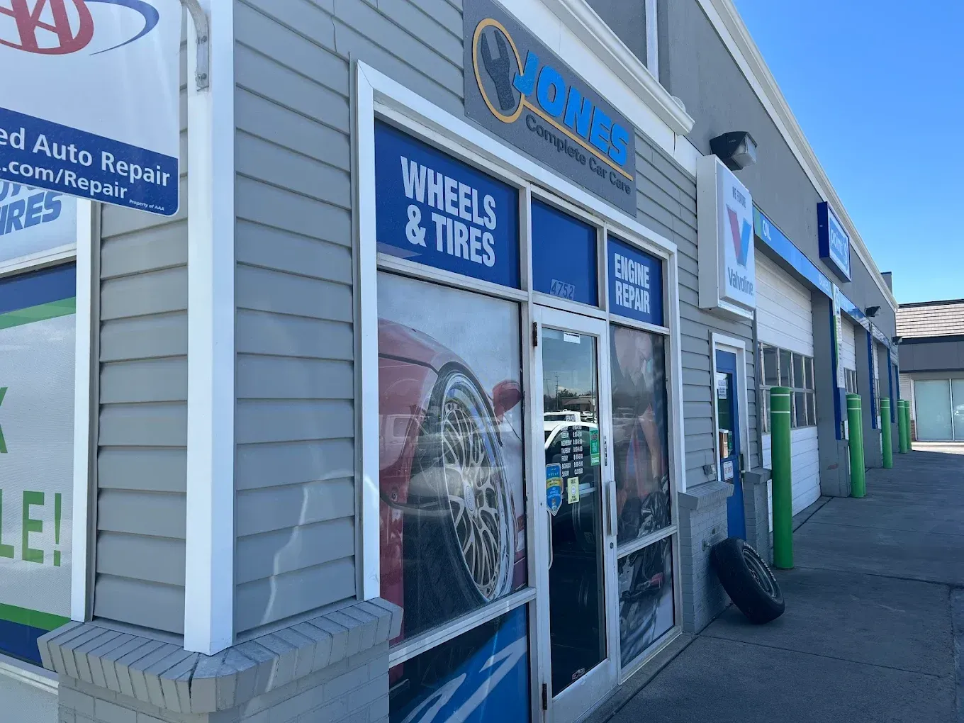 Auto repair shop storefront with wheels and tires signage and parked tire by the entrance | Jones Complete Car Care
