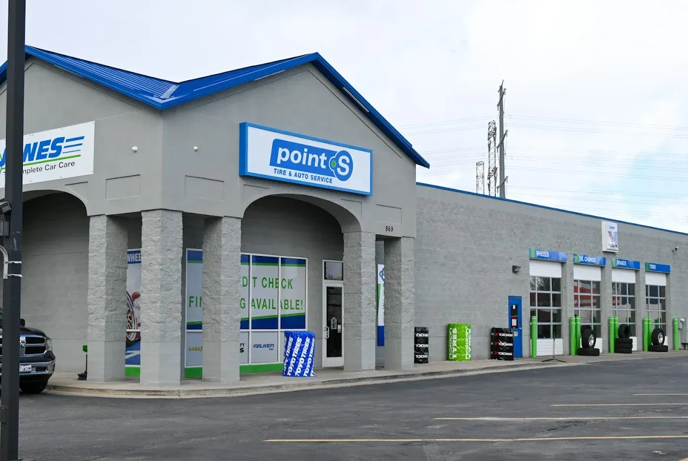Exterior of a Point S auto service building with blue roof trim and parking lot | Jones Complete Car Care