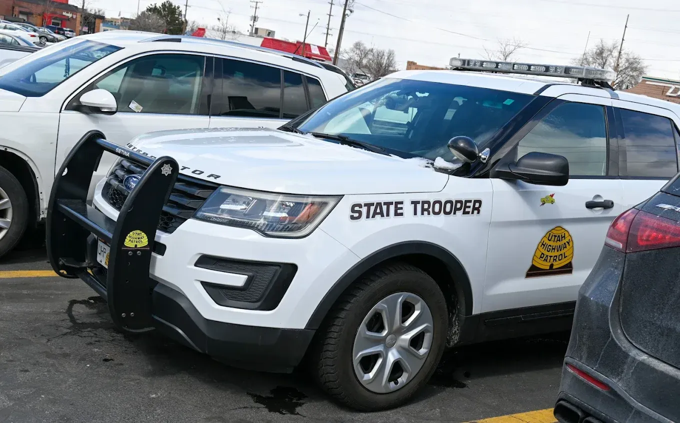 State trooper SUV parked in a lot, white with black front push bumper and state patrol markings. | Jones Complete Car Care