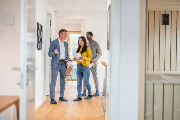 A group of people are standing in a hallway looking at a house.