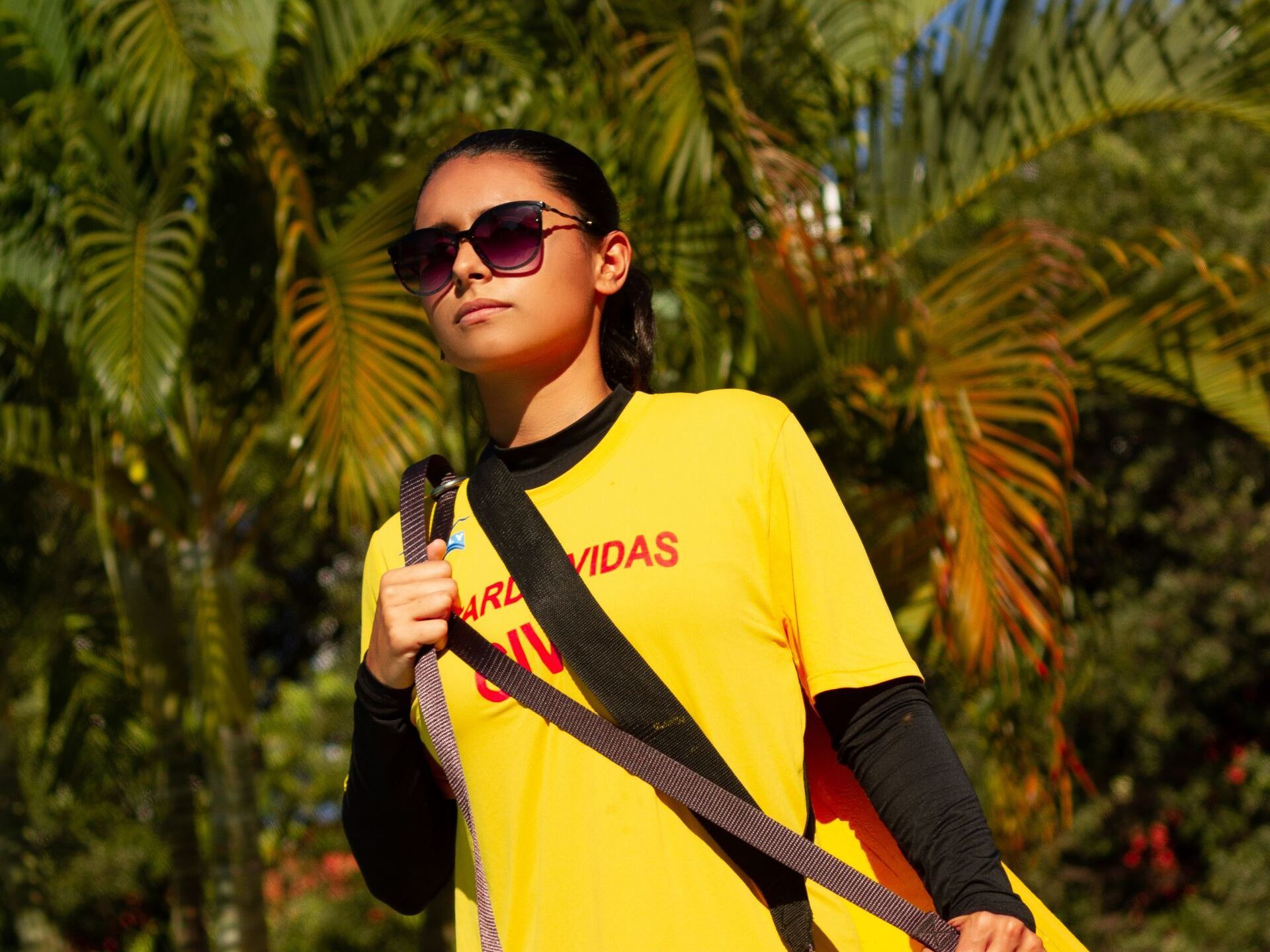 A woman wearing sunglasses and a yellow shirt that says vidas