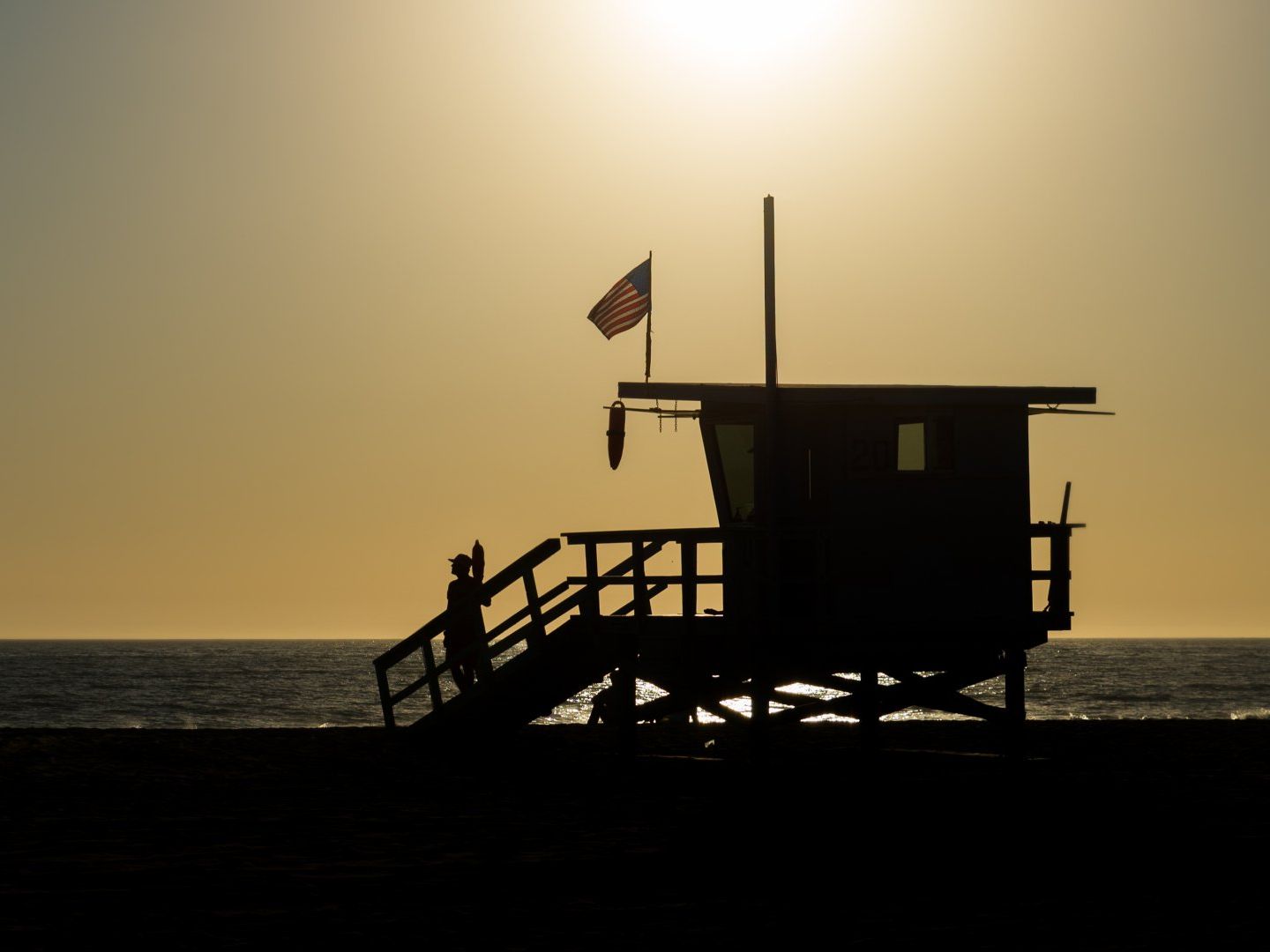 A silhouette of a lifeguard tower on the beach