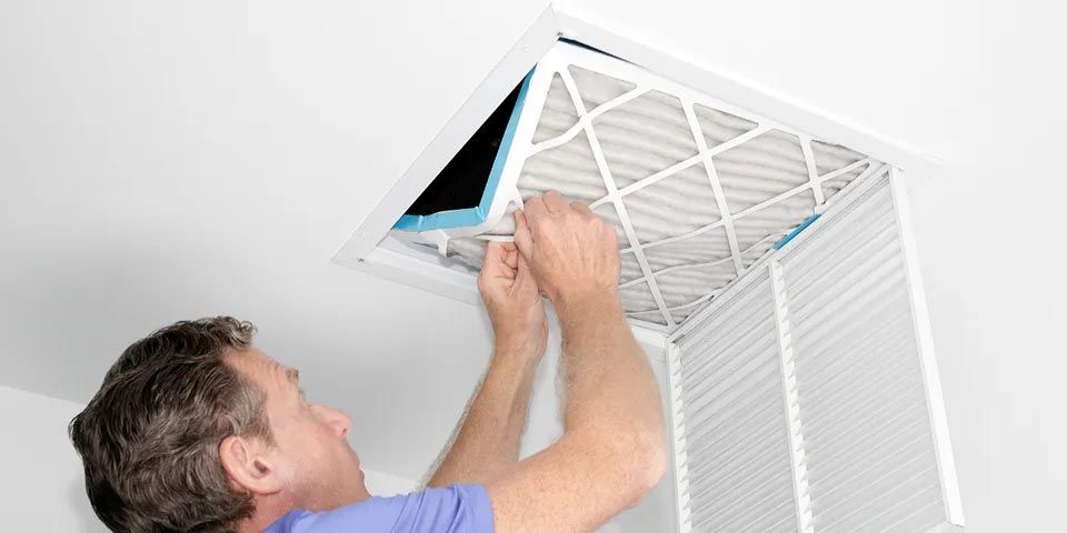 Man Removing Dirty Air Filter — Vashon, WA — Vashon Heating & Cooling