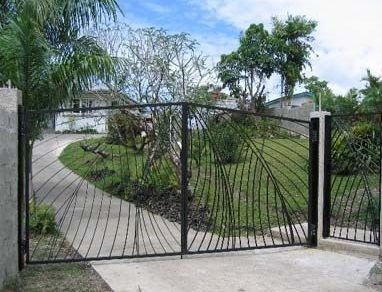 Gate and pedestrian door with coconut leaves in copper by Shane Bower, Fiji 