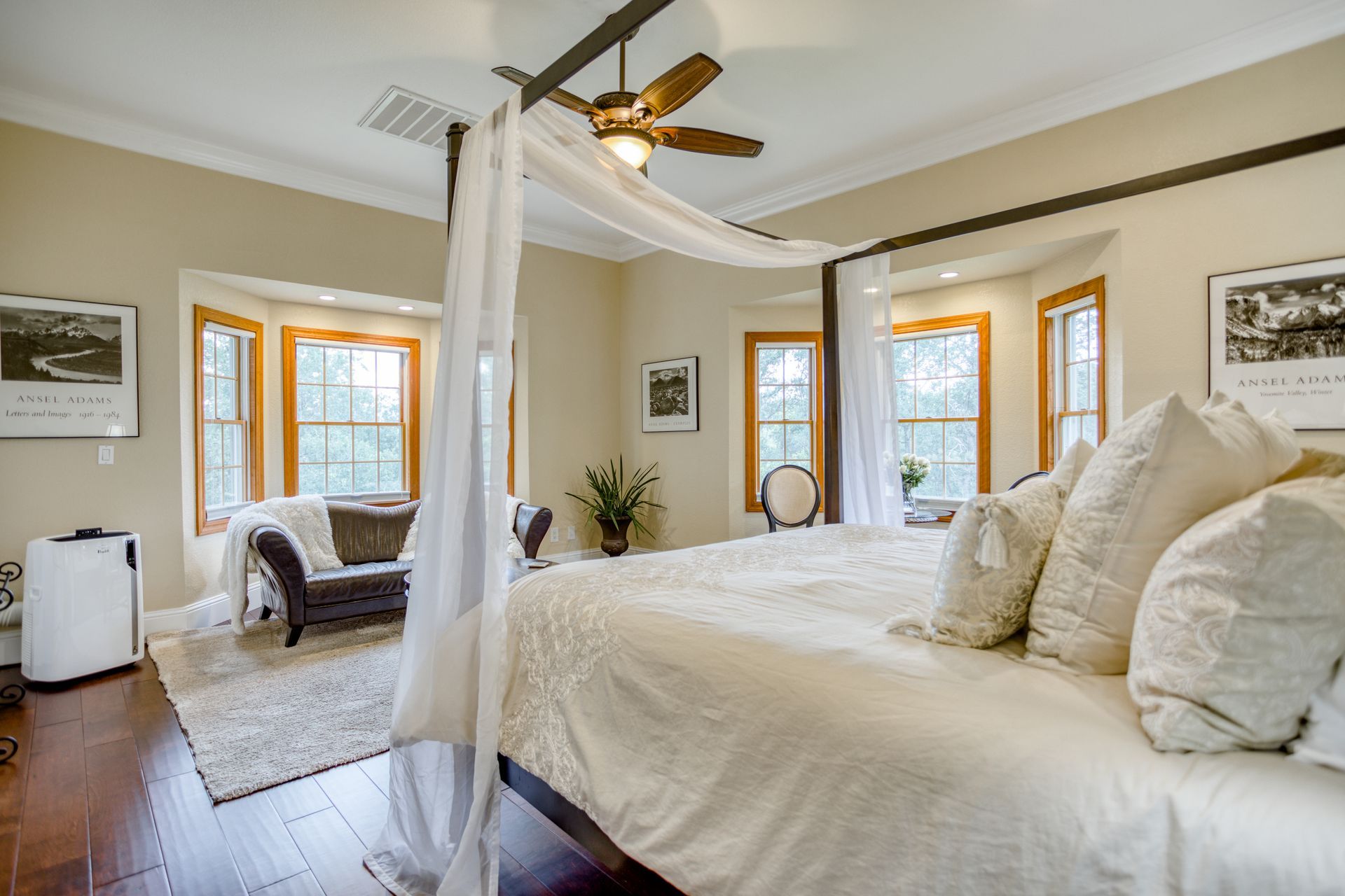 A bedroom with a canopy bed and a ceiling fan.
