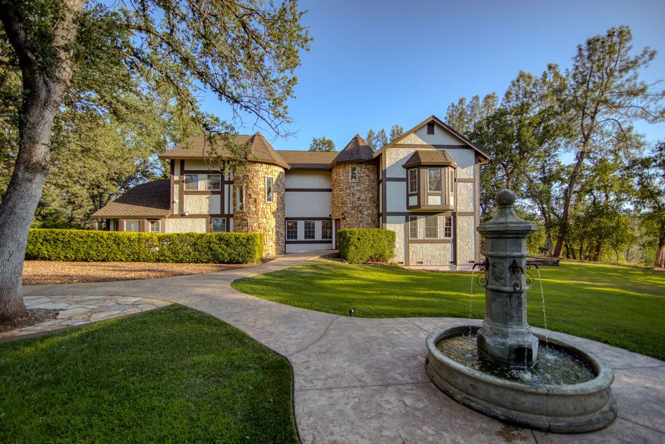 A large house with a fountain in front of it