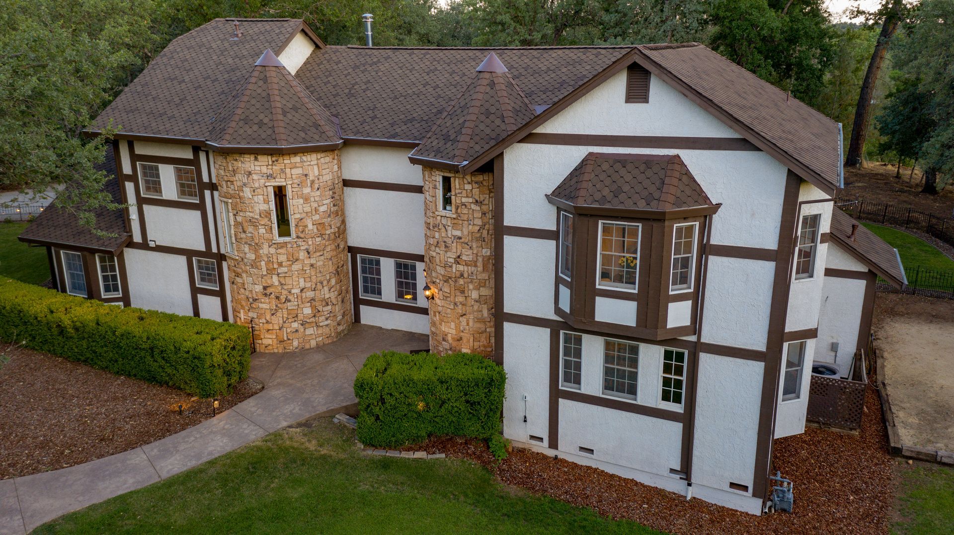 An aerial view of a large white and brown house