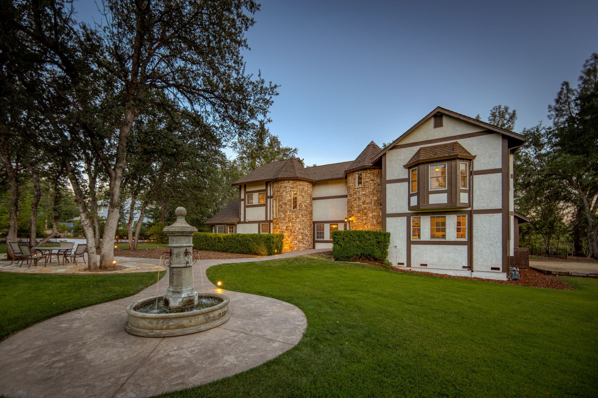 A large house with a fountain in front of it