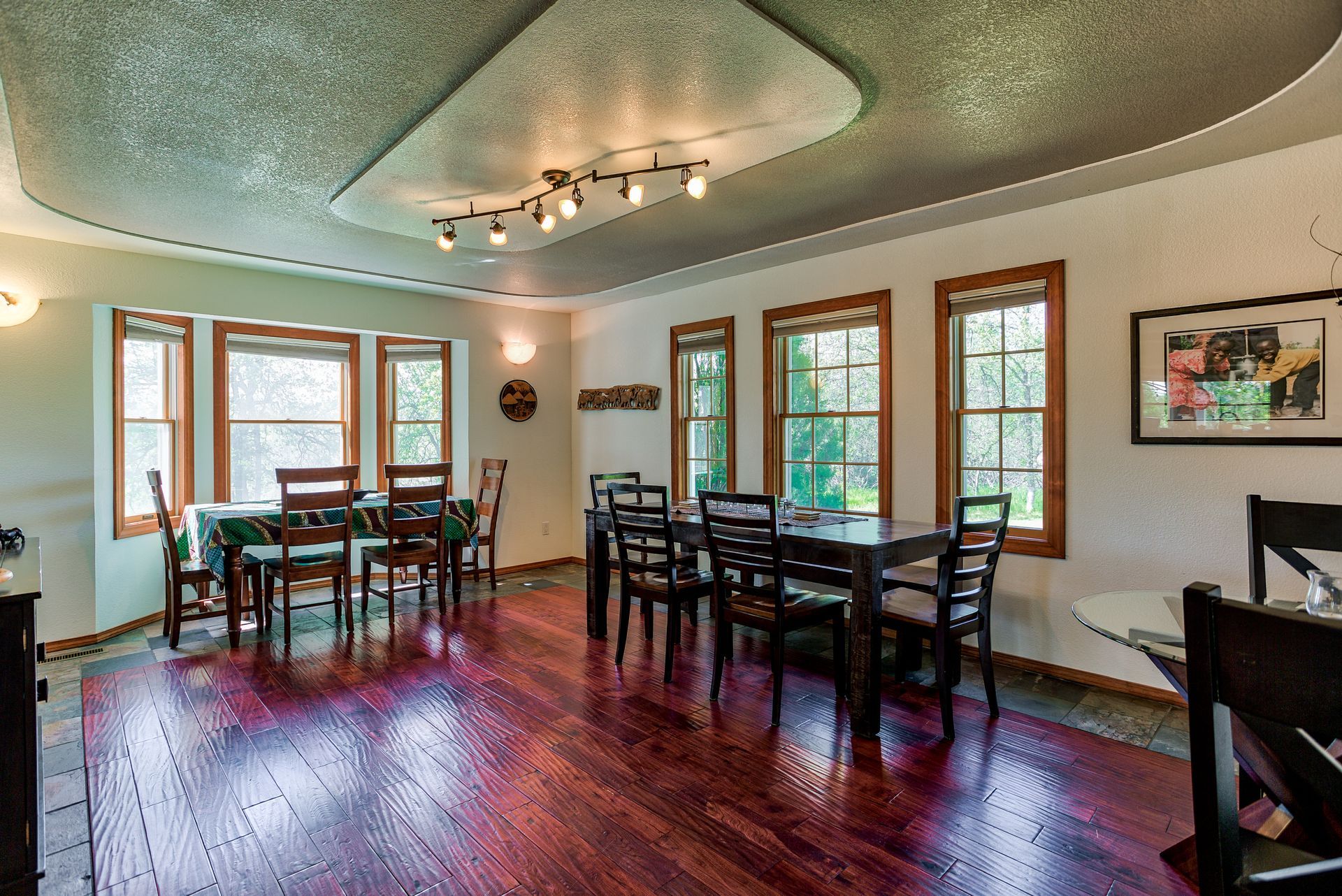 A large dining room with hardwood floors and tables and chairs.