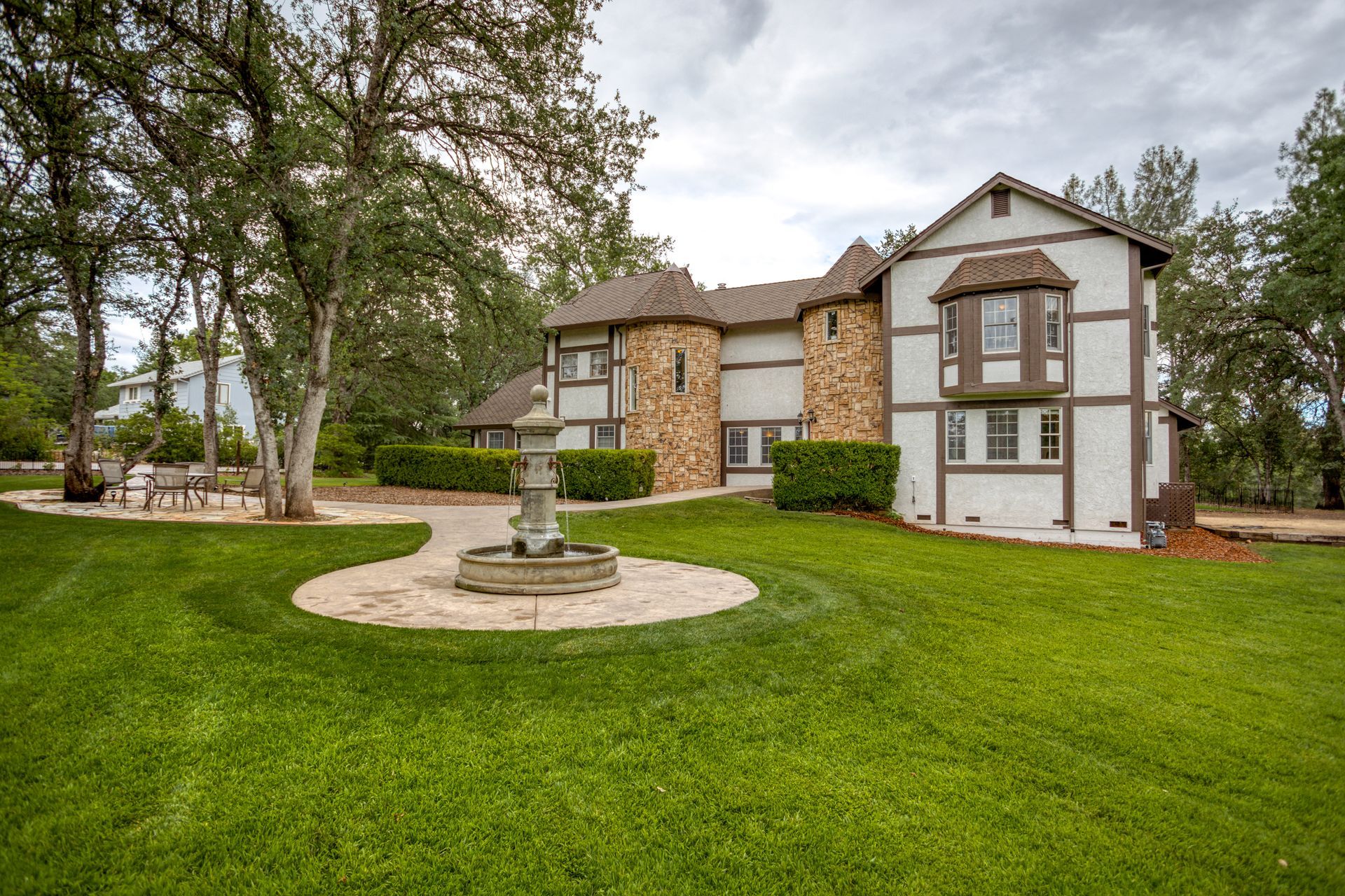 A large house with a fountain in front of it