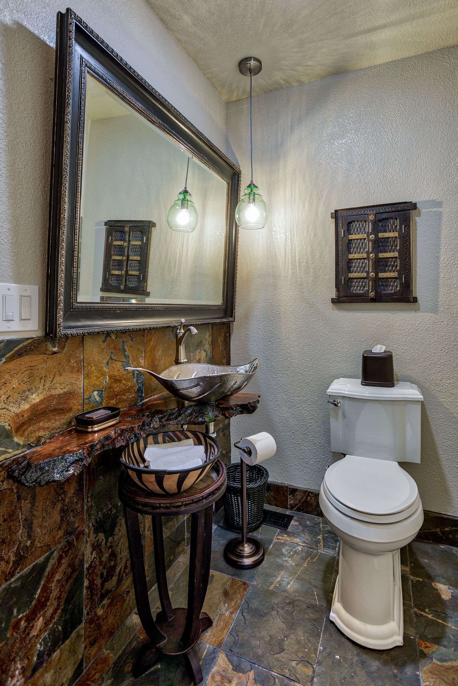 A bathroom with a toilet , sink and mirror.
