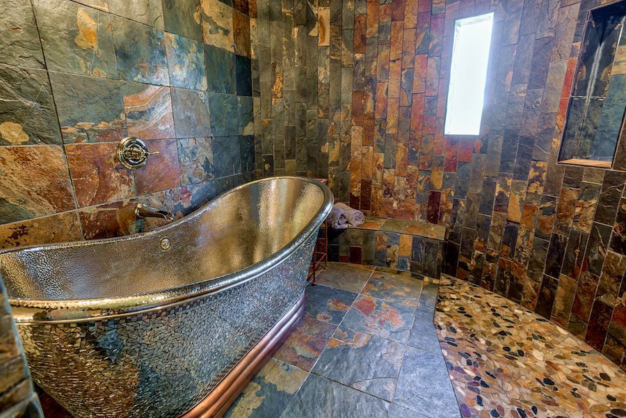 A bathroom with a stainless steel tub and a window.