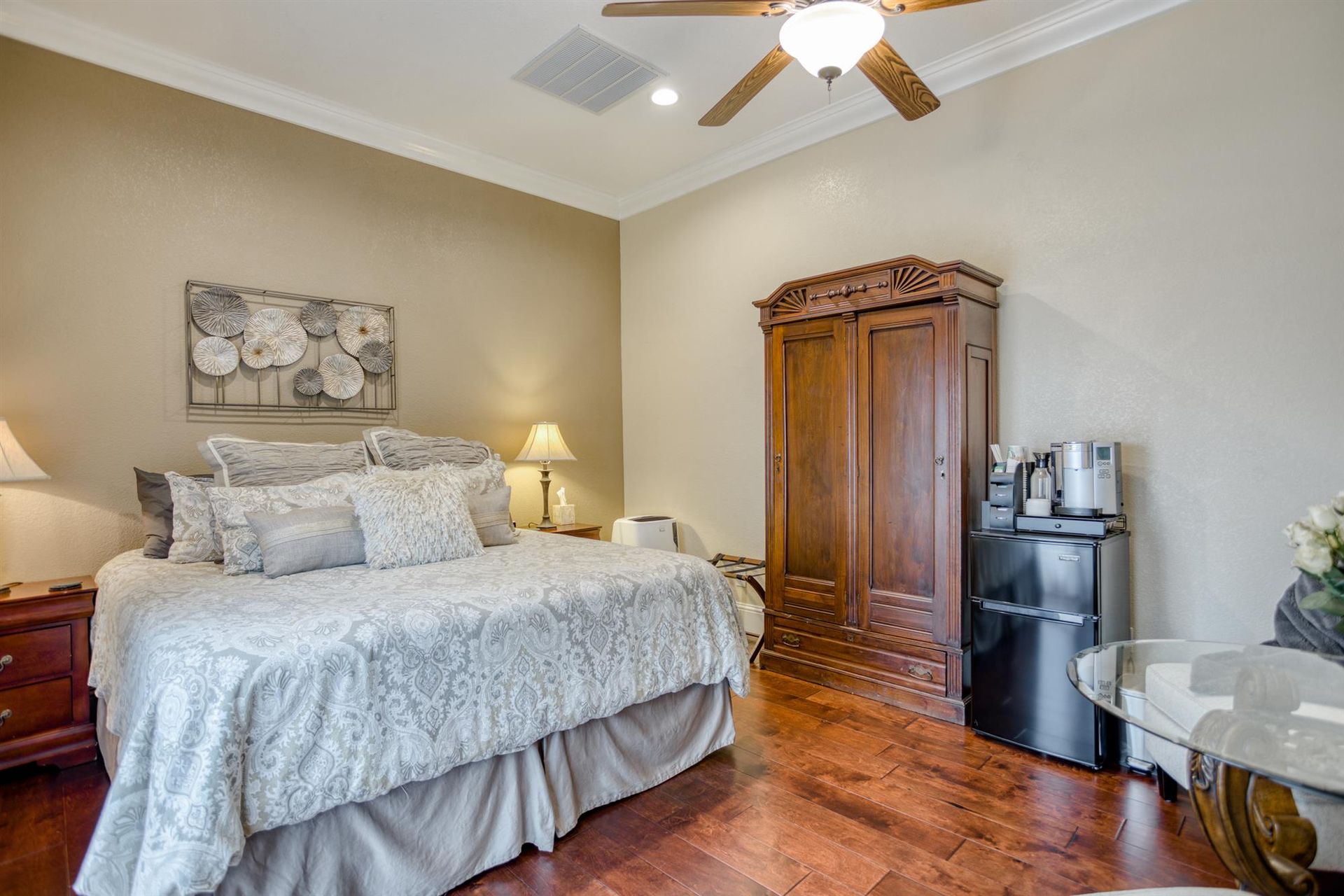 A bedroom with a large bed and a ceiling fan.