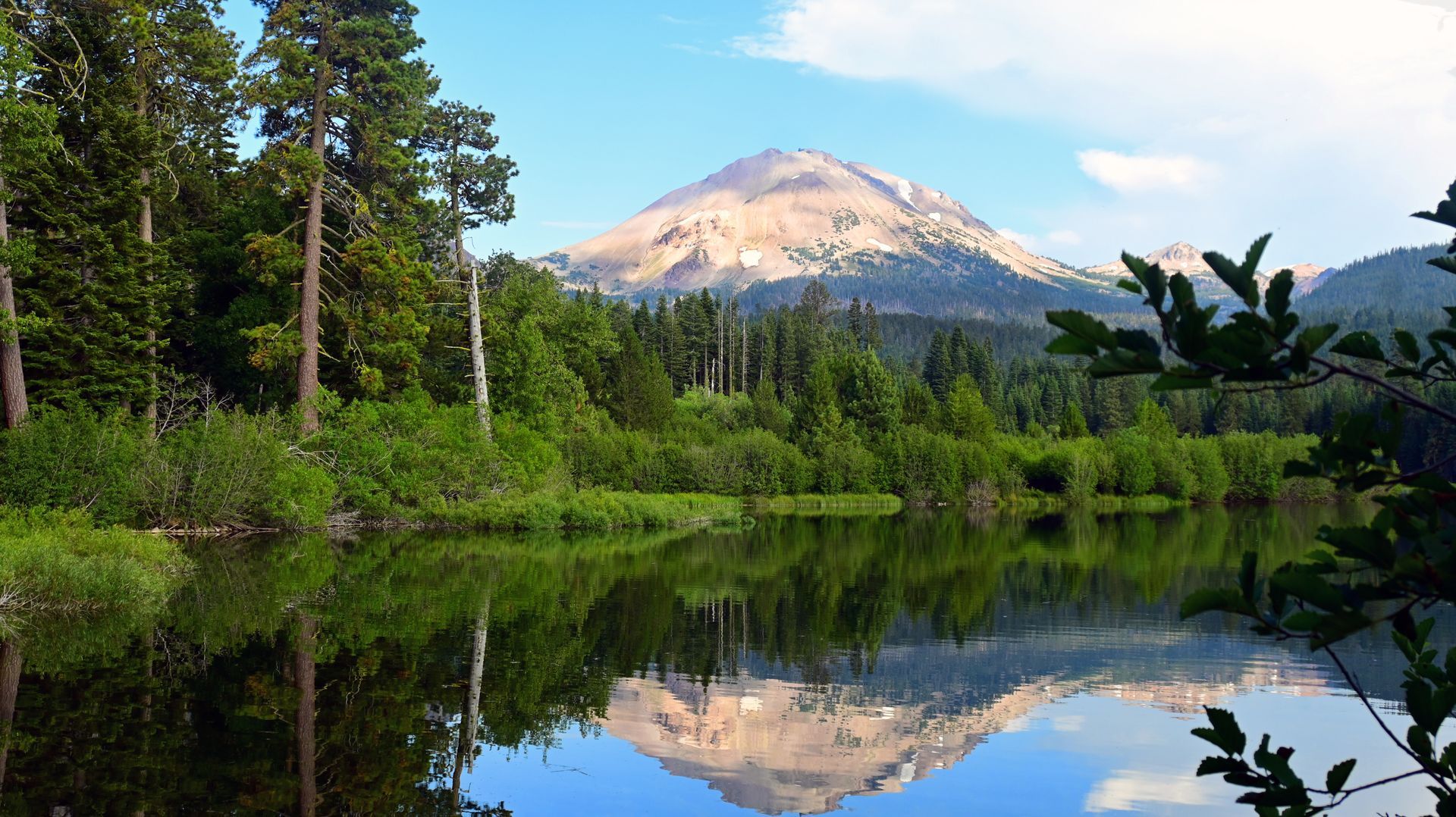 A mountain is reflected in a lake surrounded by trees