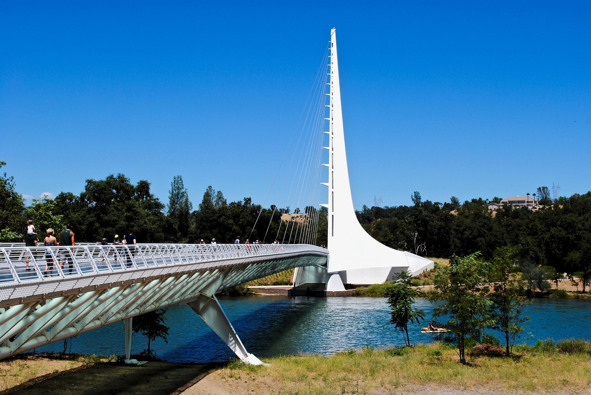 A bridge over a body of water with a sailboat in the background