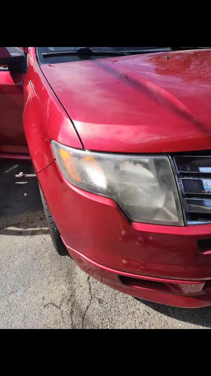 A red car is parked on the side of the road.
