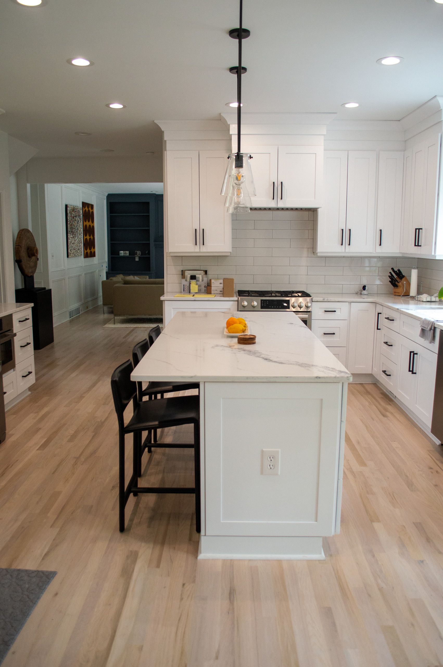 A kitchen with white cabinets and a large island in the middle.