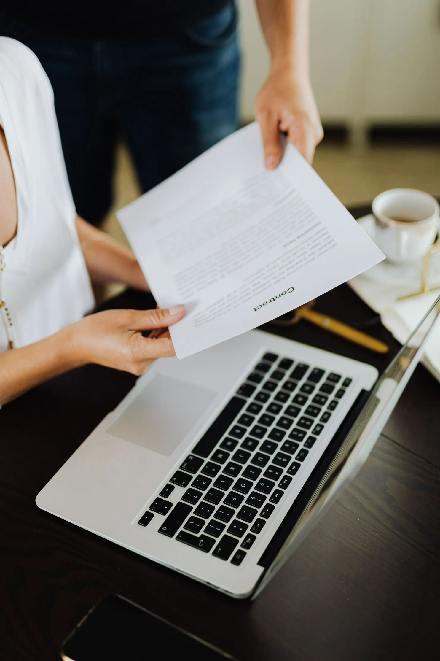 Person Handing Document to Another at — All Finanz & Insurance Solutions Mackay in North Mackay, QLD
