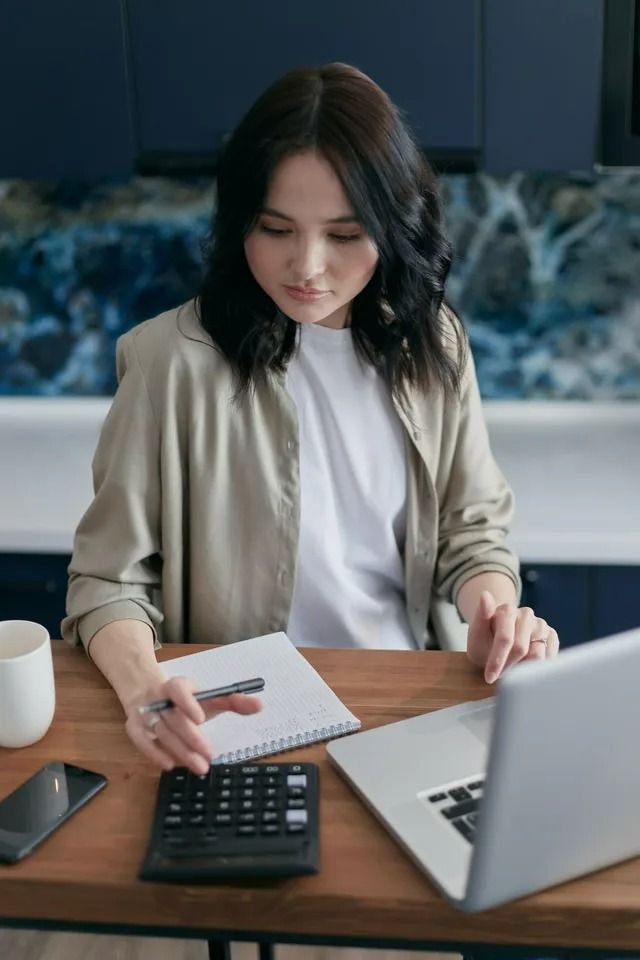 Woman Working With Financial Records at  a Table — All Finanz & Insurance Solutions Mackay in North Mackay, QLD