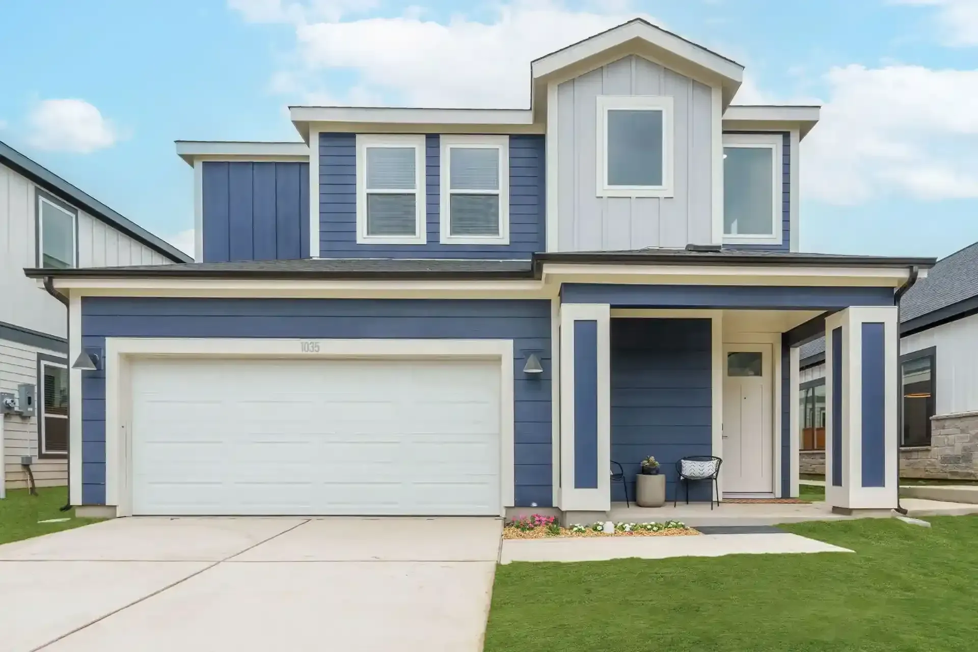 Exterior view of a modern residential building complex with green lawn and blue sky