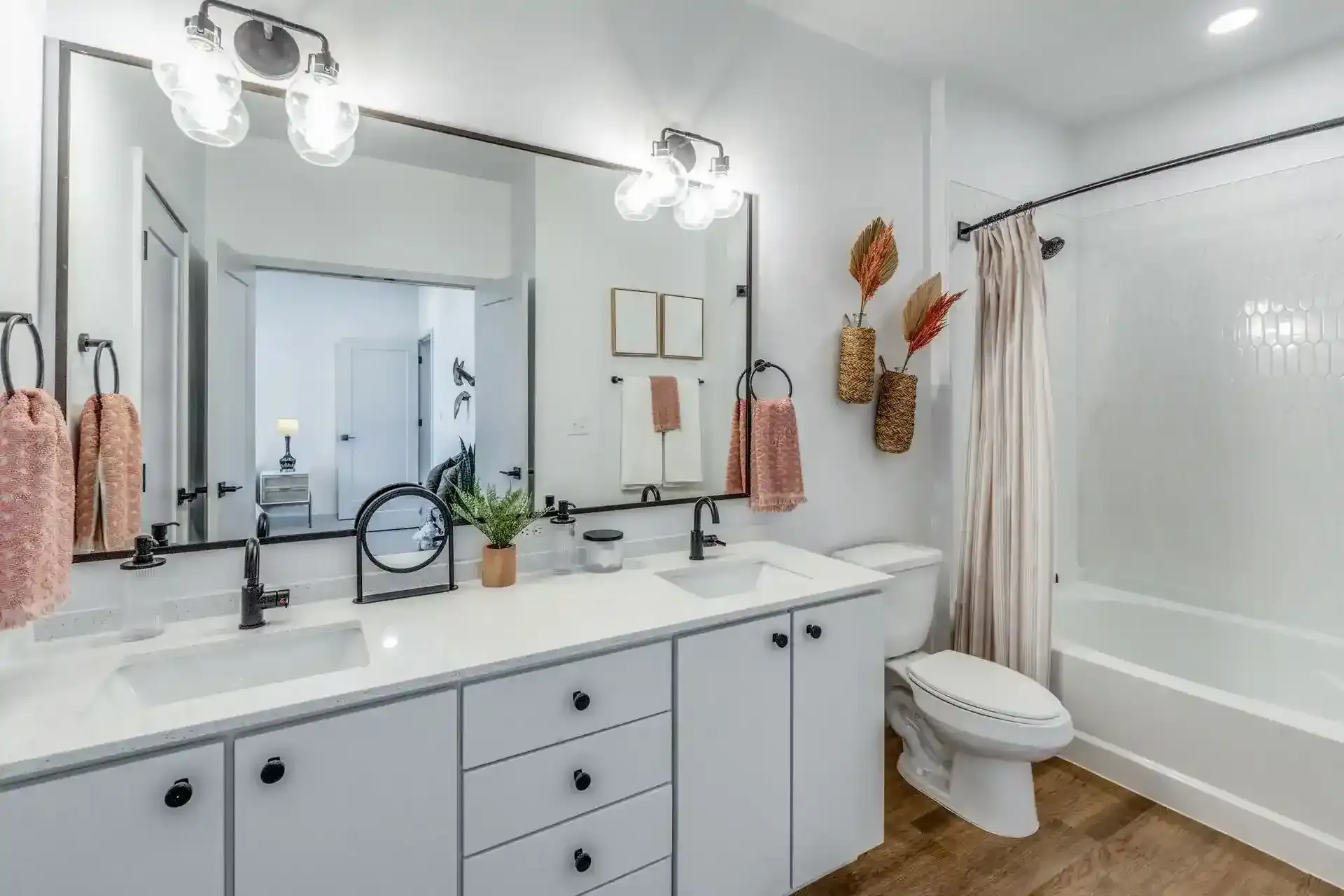 Modern bathroom featuring a double sink, large mirror, and stylish decor.