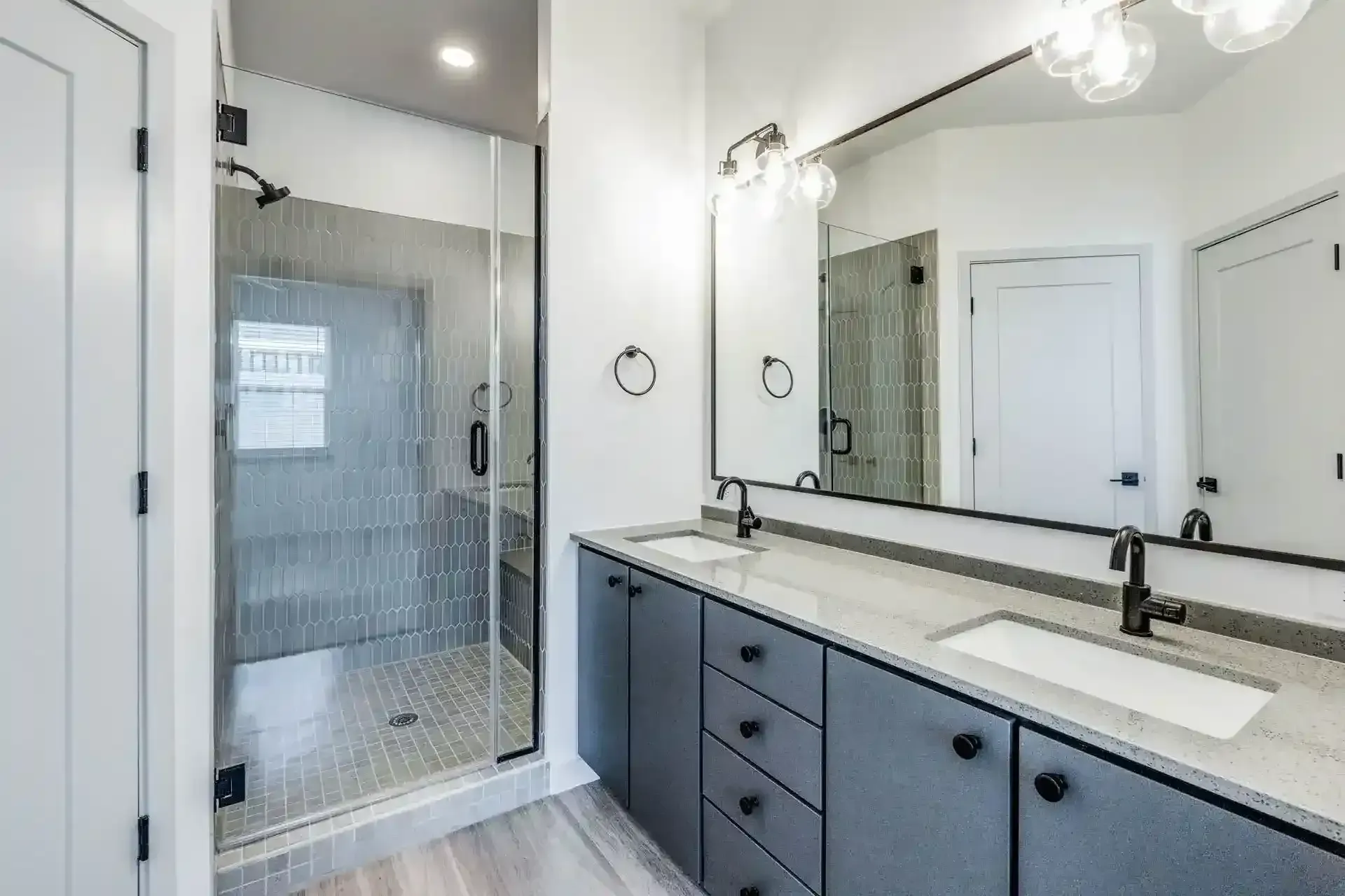 Modern bathroom featuring a walk-in shower and dual sinks.