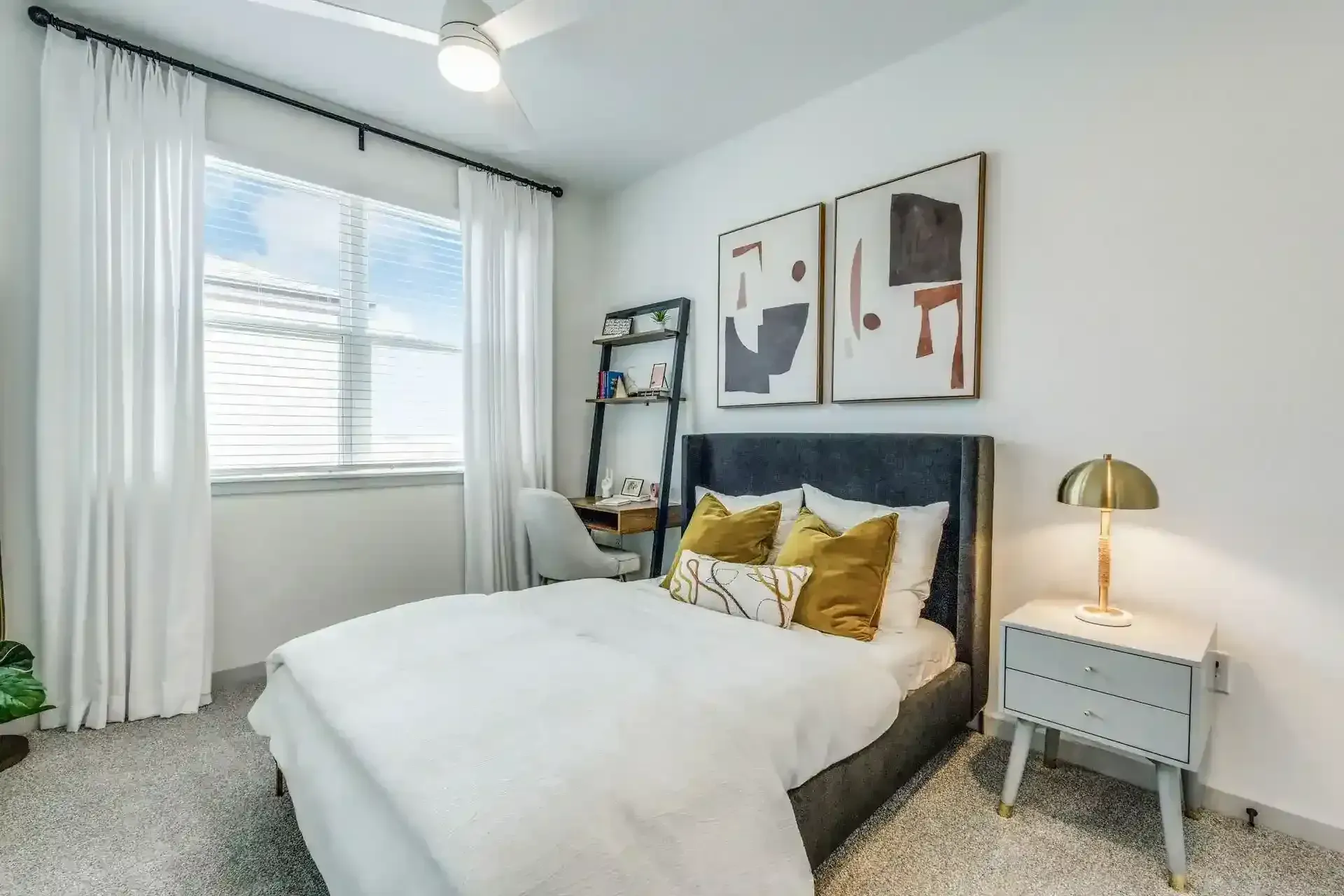 2 Bedroom Luxury Apartments in New Braunfels, TX - Villas at Creekside - A Bedroom with Contemporary Artwork, and a Window with White Curtains.