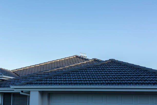 A house with a tiled roof and a blue sky in the background.