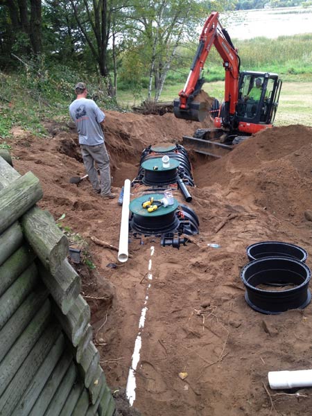 Man and excavator on the construction site — Cedar, MN — Casper's Excavating
