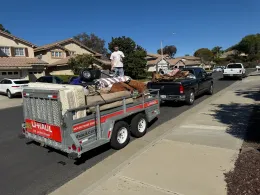 A man is standing on top of a trailer that says u-haul on it