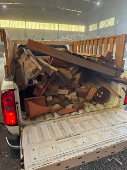 The back of a truck filled with wood and bricks.