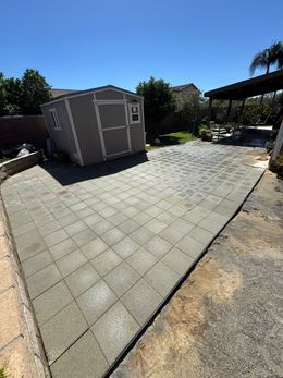 A shed is sitting in the middle of a driveway.