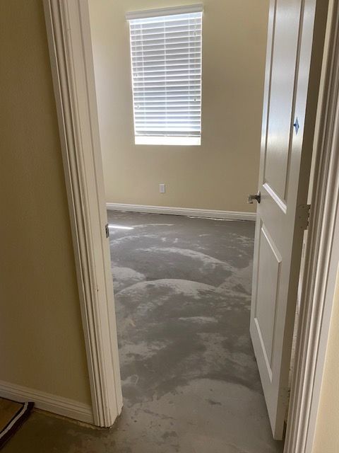 A room with a carpeted floor and a window.