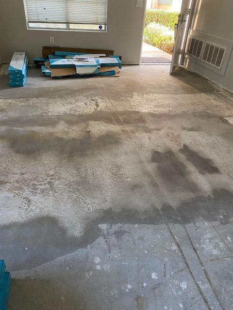 A room with a concrete floor and a stack of boxes on the floor.