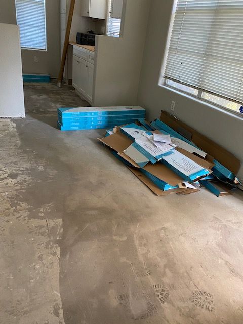 A room with a lot of cardboard boxes on the floor.