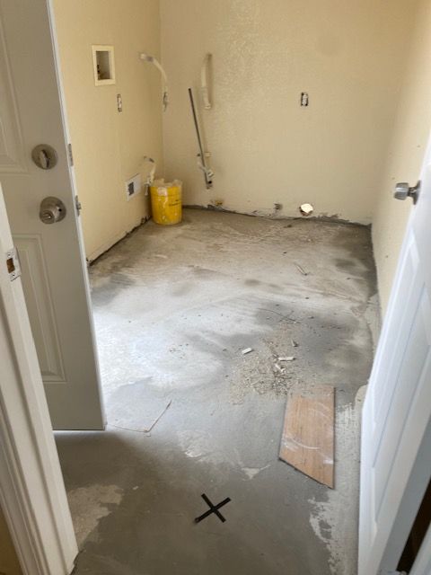 A dirty room with a x on the floor