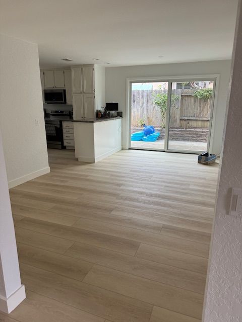 A living room with light waterproof laminate floors and a sliding glass door