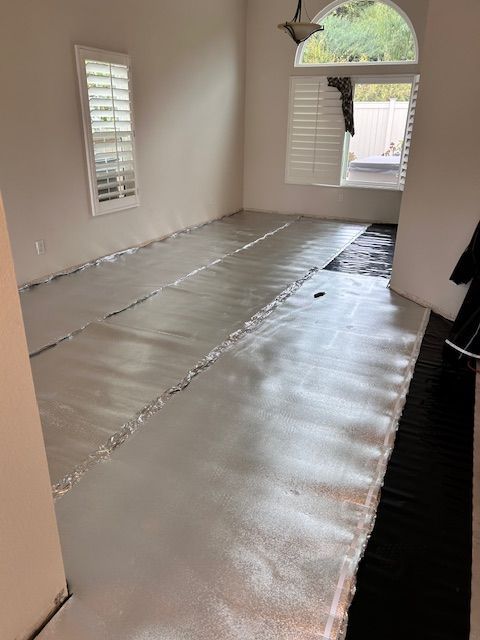 A living room with a large piece of underlayment on the floor.