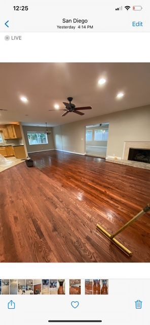 A picture of a living room with hardwood floors and a ceiling fan.