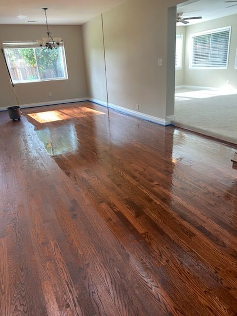 A living room with hardwood floors and a window.