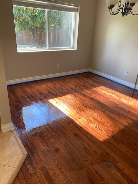 A living room with hardwood floors and a window.