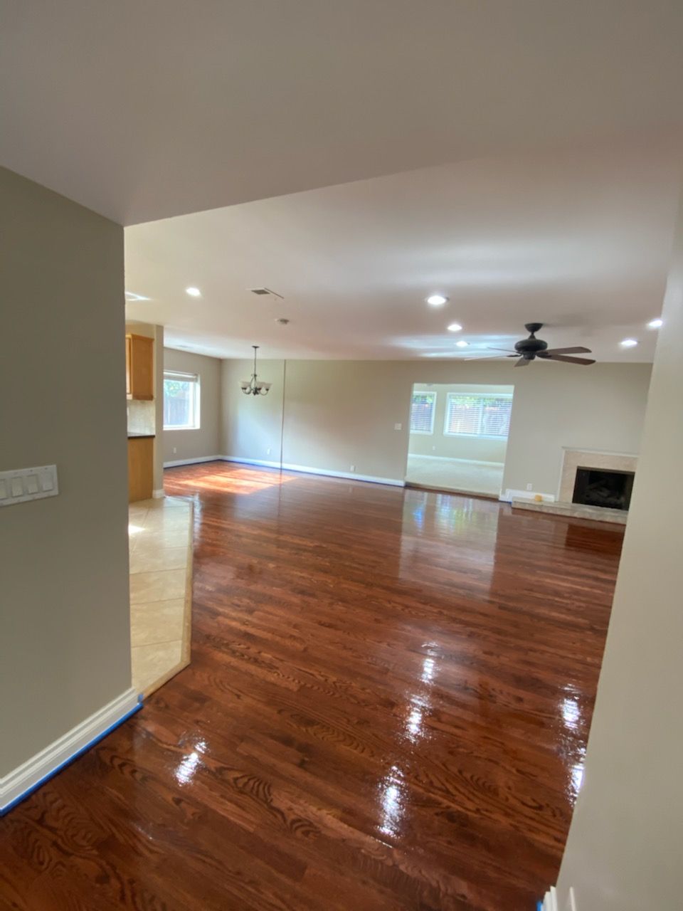 An empty living room with hardwood floors and a ceiling fan.