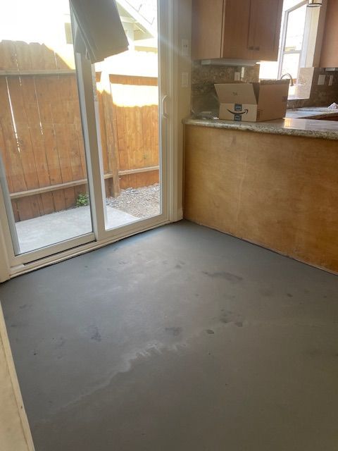 A kitchen with a sliding glass door and a gray floor.