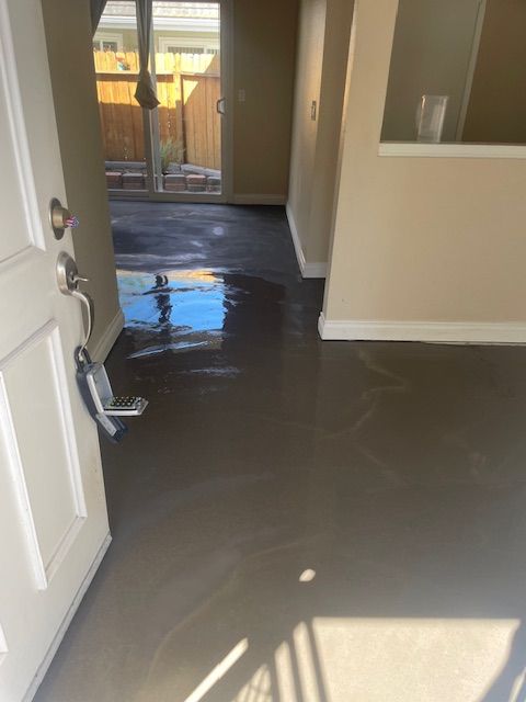 A hallway with a sliding glass door and a mop on the floor