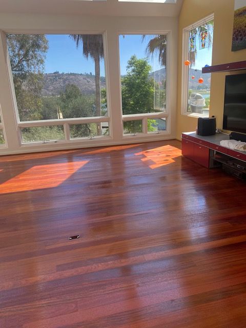 A living room with hardwood floors and lots of windows.