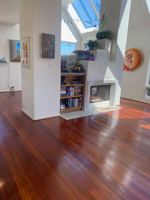 A living room with hardwood floors and a fireplace.